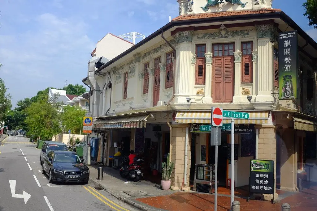 A two-storey Peranakan shophouse with ornate tiles and shuttered windows